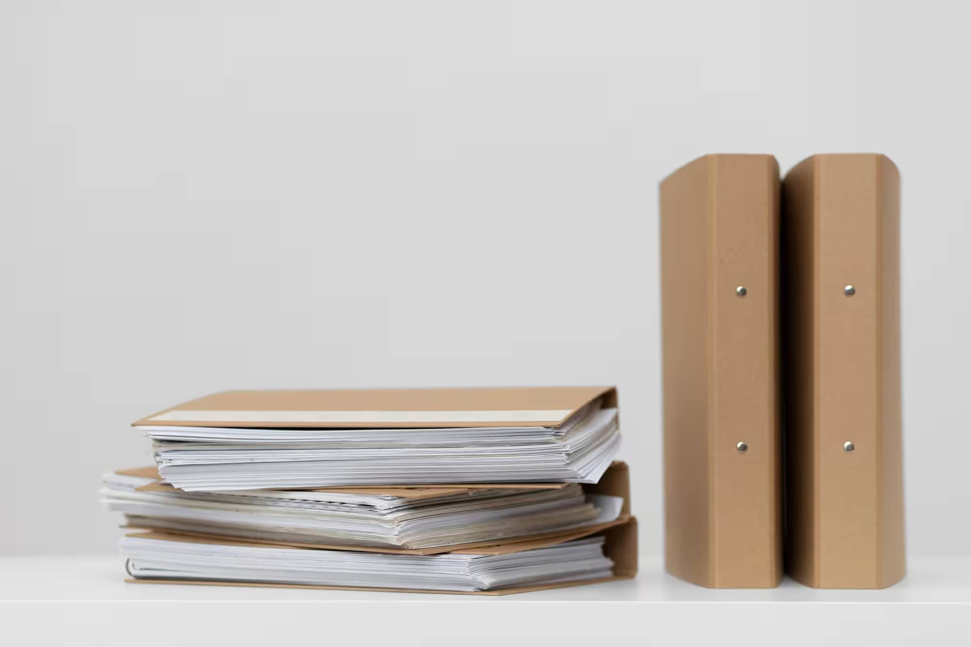 Stack of brown folders and binders with documents