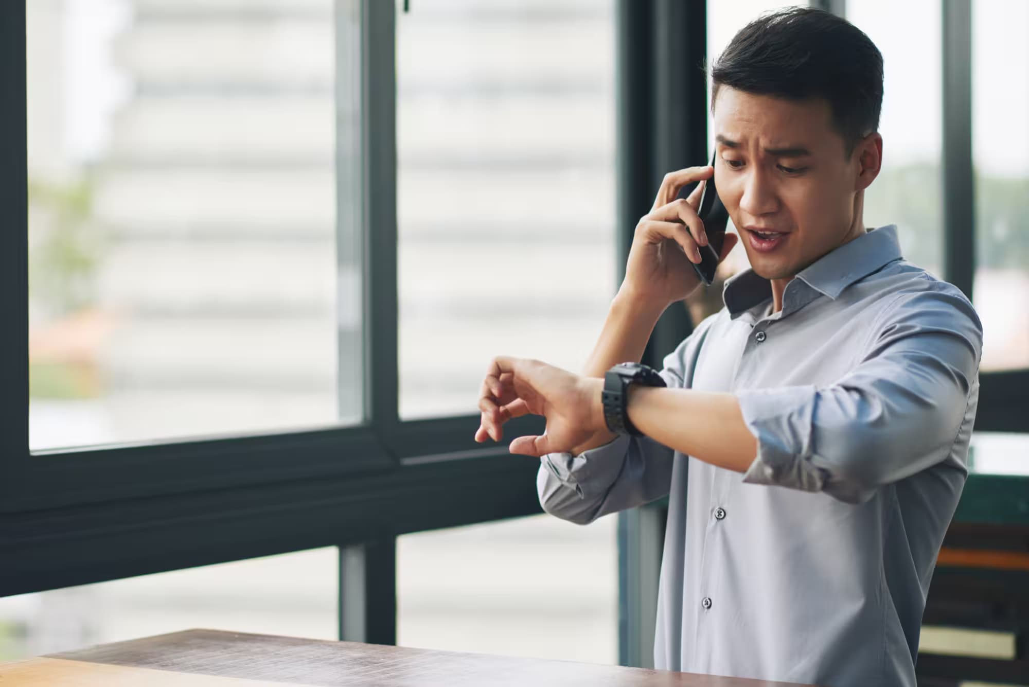 Man checking time while talking on the phone